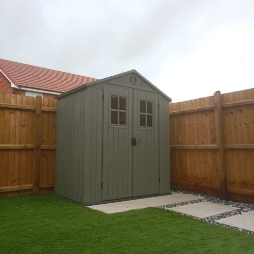An image of a large green shed with double doors built by Wise Roots