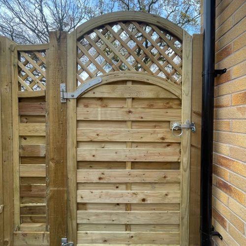 A pretty garden fence and gate with a fence topper done by Wise Roots